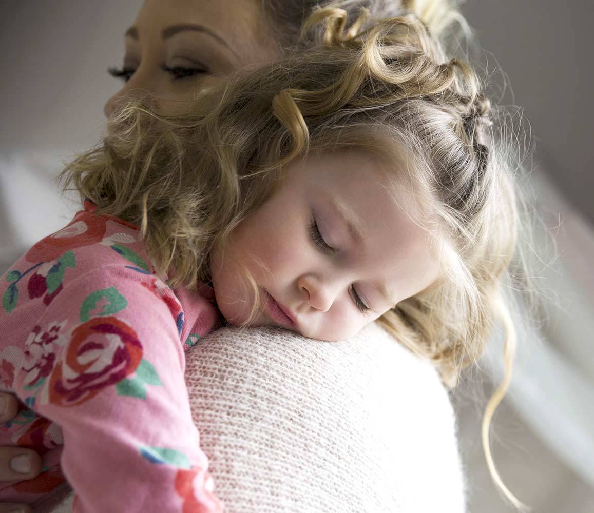 Toddler sleeping in Mothers arms