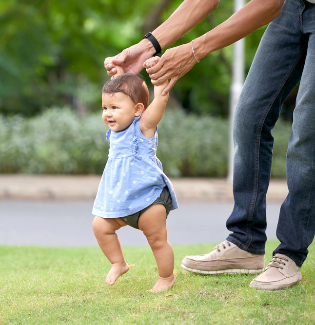 Baby taking its first steps milestone